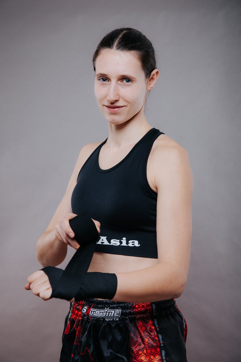 Jana, ISKA-Weltmeisterin, wickelt eine schwarze Boxbandage um Hand und Handgelenk